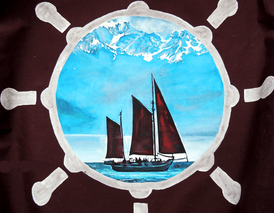 Sailboat framed in a pale circle on dark cloth, painted for a sail cover.