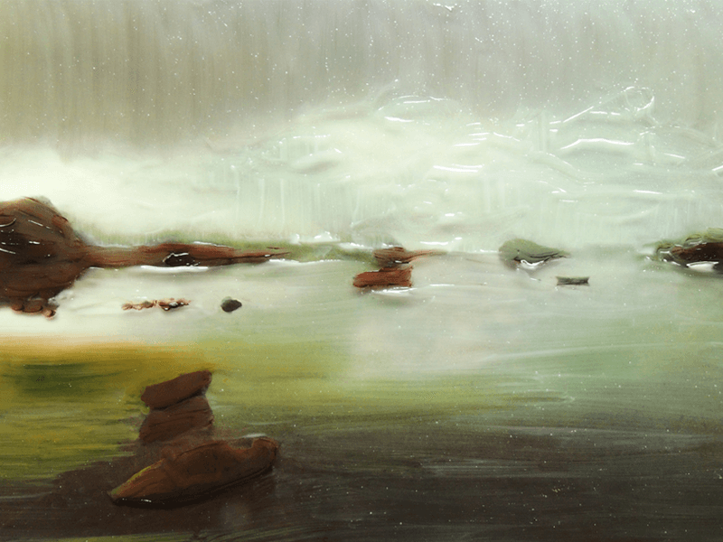 Still of a misty green swamp with dark rocks lying in the shallows.